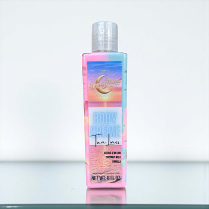 A bottle of Body Creme lotion in the scent Tan Lines. The bottle is clear and the lotion inside is swirls of pink, yellow, and blue. the bottle sits on a white surface against a white background 