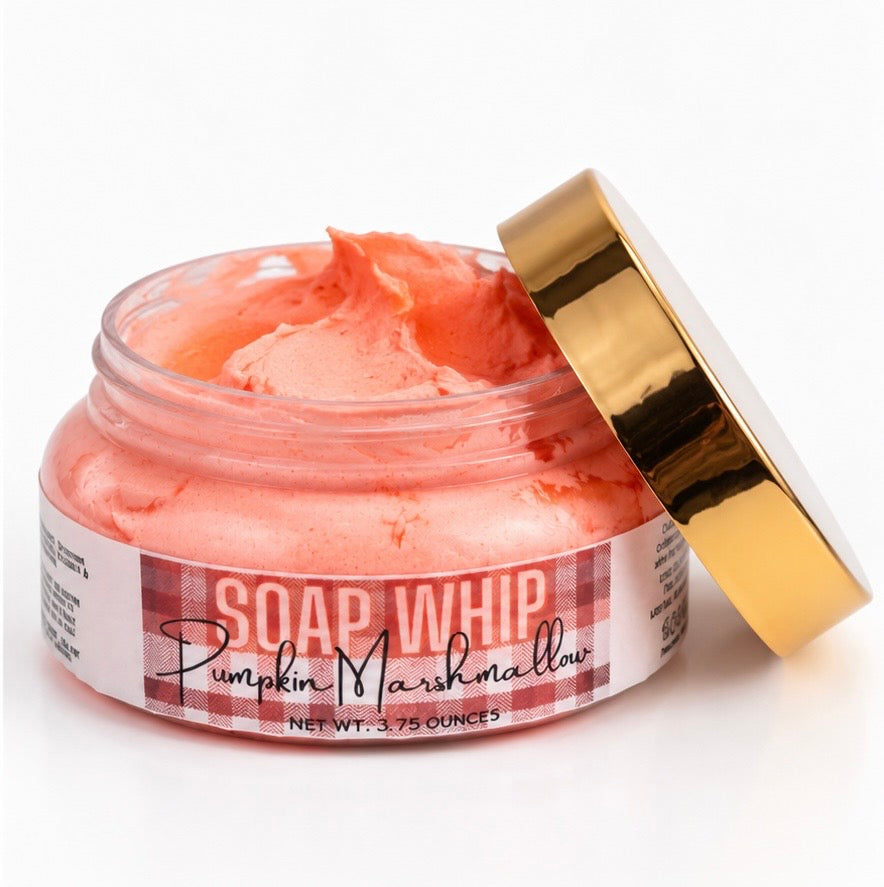 An open jar of Soap Whip in the scent Pumpkin Marshmallow with its shiny gold lid leaning against it showing the fluffy soap whip in the jar, on a clean white background.