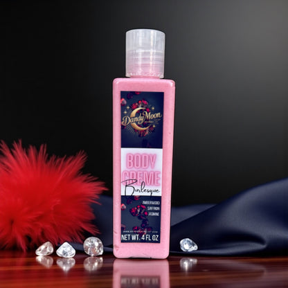 bottle of Dandy Moon body crème lotion with decorative elements of red feathers and diamonds on a dark background with black satin draped in the background