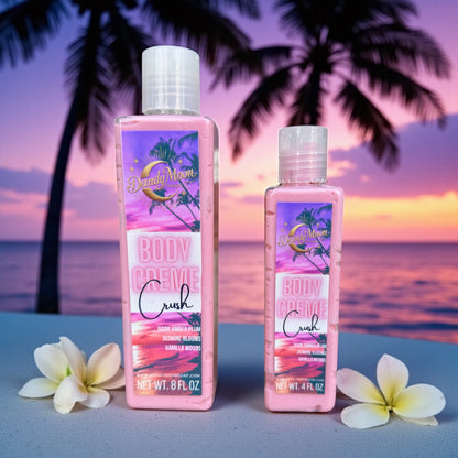 Two bottles of Dandy Moon Body Creme lotion in Crush scent against a tropical sunset background with palm trees and flowers next to the bottles
