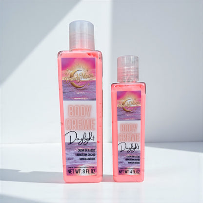 Two bottles of Body Creme lotion in Daylight scent, the bottles are clear and the lotion is coral color, against a white background