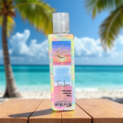 A bottle of body creme lotion in the scent tan lines sits on a wooden surface with a beach and palm trees in the background