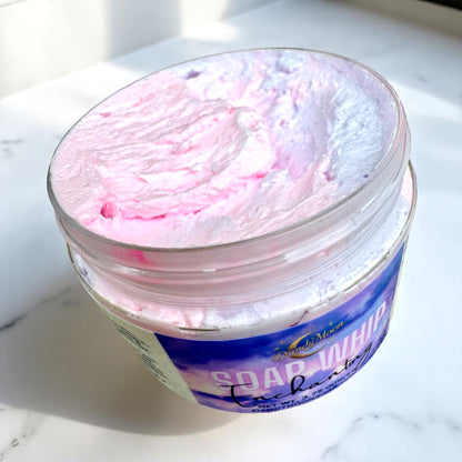 an open jar of pink and purple soap whip on a white marble surface