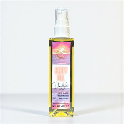 Bottle of body oil with a colorful pink and purple label against a white background