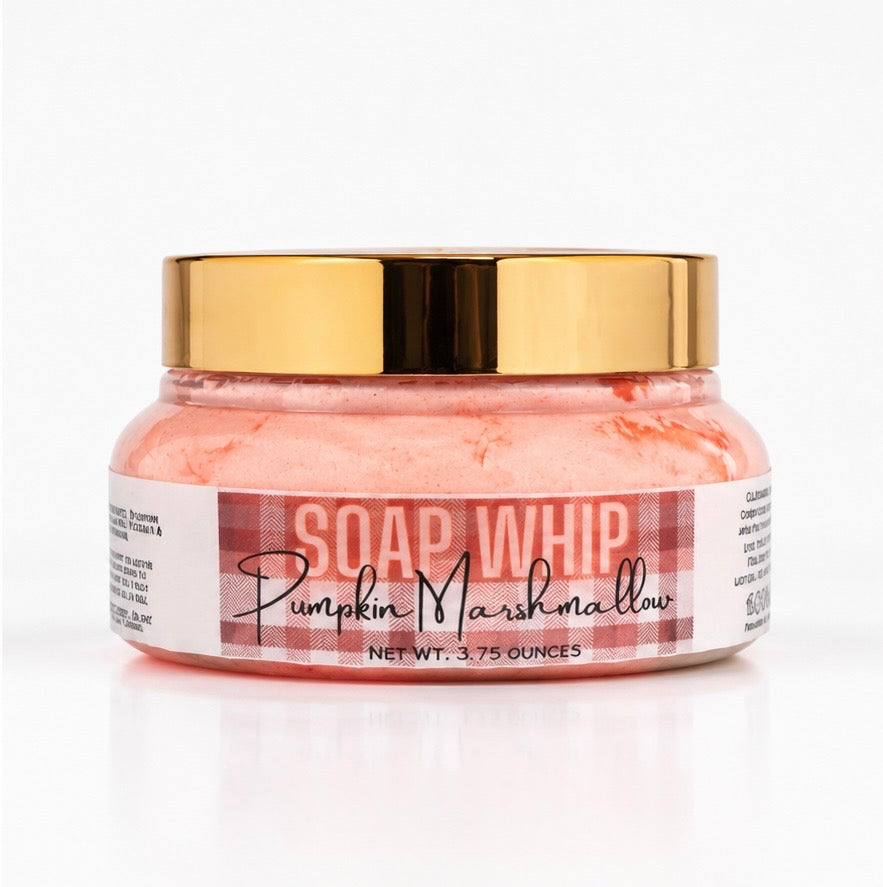 A jar of Soap Whip in the scent Pumpkin Marshmallow, with a shiny gold lid and a white label featuring a brown and cream colored plaid pattern, set against a clean white background and surface.