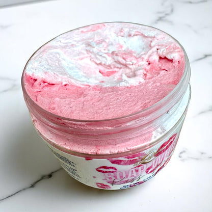 an open jar of pink and white whipped soap on a marble surface
