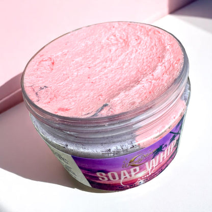 an open jar of pink and purple soap whip with a purple label on a white background