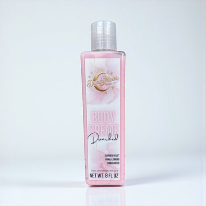Body crème lotion bottle in the scent drenched with pink label against a white background