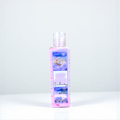 a bottle of body creme lotion in the scent enchanting. the bottle is clear and the lotion inside is swirls of purple and pink. the bottle stands on a white surface against a white background