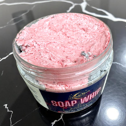 Red soap whip in a jar on a black marble surface