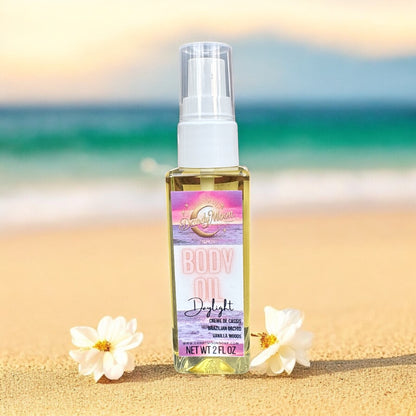 Body oil bottle with colorful pink and purple label, sitting on a sandy beach with white flowers scattered on each side of the bottle, against and ocean background