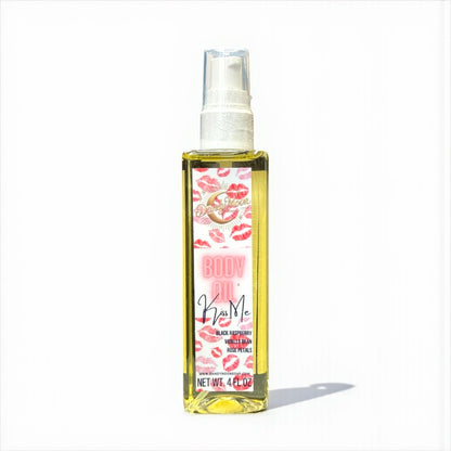 Bottle of Kiss Me body oil with a pink and red lips label sitting on a white surface with a white background